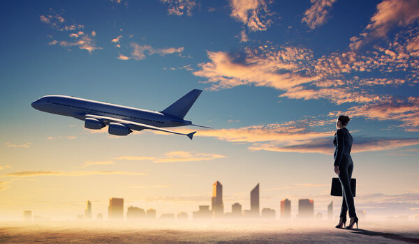 Деловая женщина смотрит на самолет в небе
