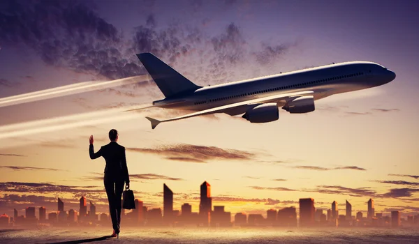 Üzleti nő keresi a repülőgép az égen — Stock Fotó