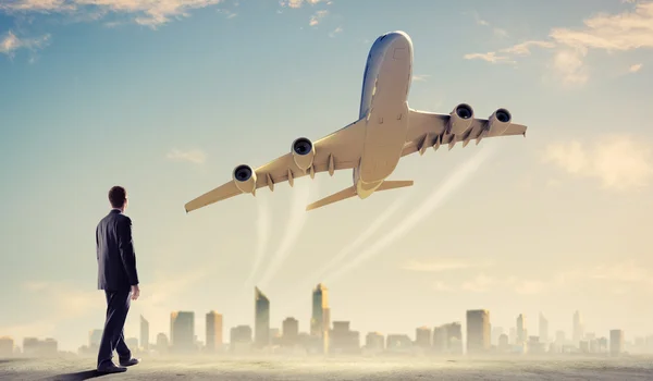 Empresário olhando para avião no céu — Fotografia de Stock