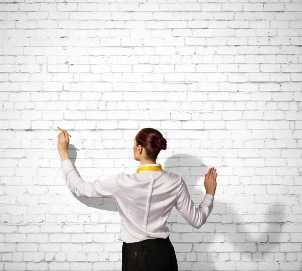 Geschäftsfrau zeichnet an Wand — Stockfoto