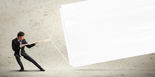 Businessman pulling banner — Stock Photo, Image