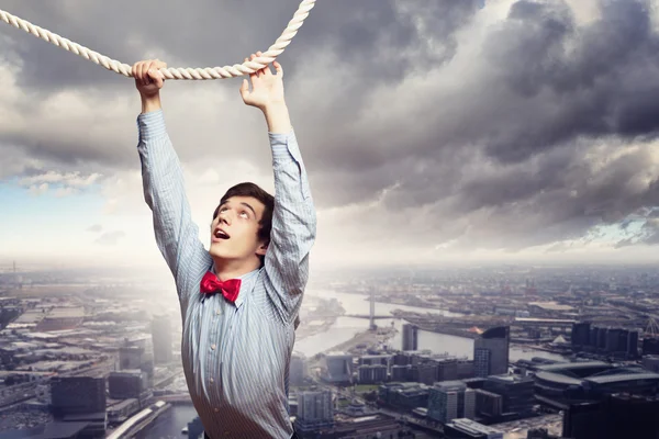 Businessman hanging on rope — Stock Photo, Image