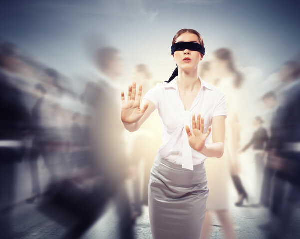 Businesswoman in blindfold among group of people