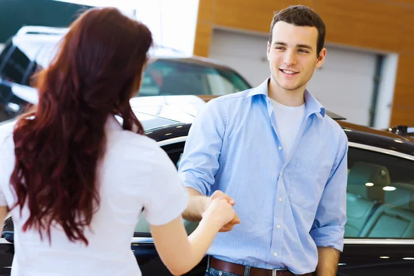 Joven pareja feliz en el salón de coches —  Fotos de Stock