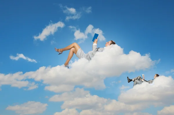 Mensen uit het bedrijfsleven liggend op wolken — Stockfoto