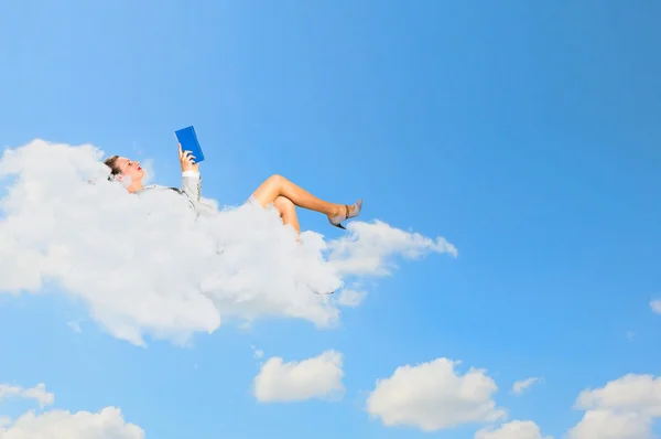 Businesswoman lying on clouds — Stock Photo, Image