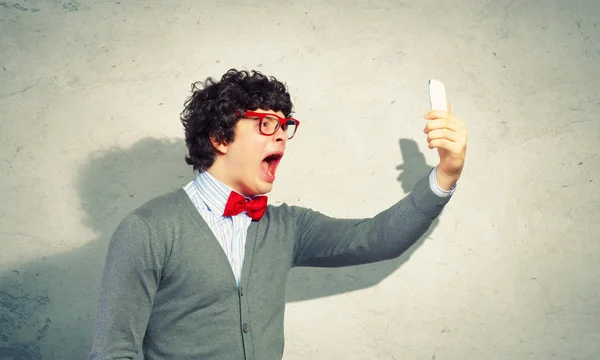 Young man shouting at his mobile phone — Stock Photo, Image