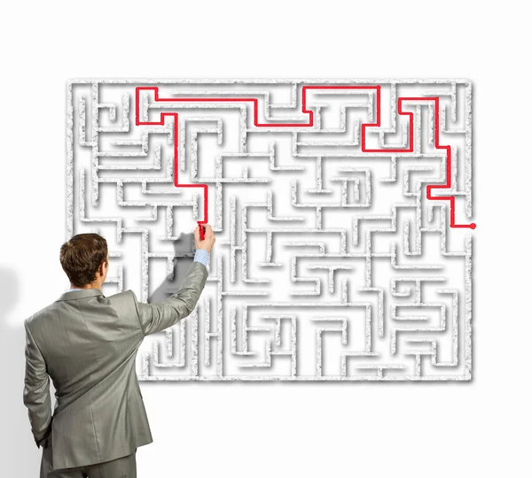 Businessman solving labyrinth problem — Stock Photo, Image