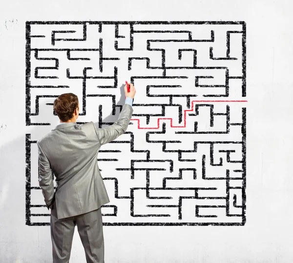 Businessman solving labyrinth problem — Stock Photo, Image