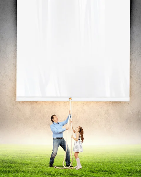 Man and little girl pulling banner — Stock Photo, Image