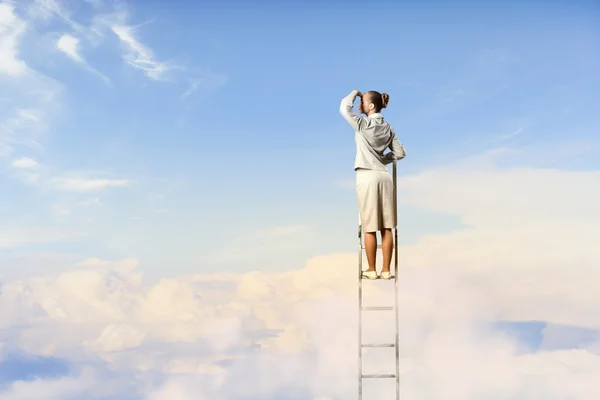 Businesswoman standing on ladder — Stock Photo, Image