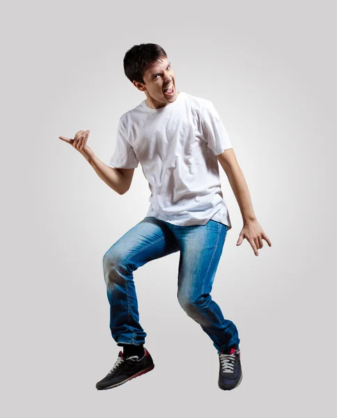 Genç adam dans ediyor ve zıplıyor — Stok fotoğraf