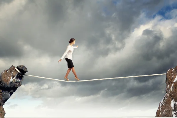 Businesswoman balancing on rope — Stockfoto