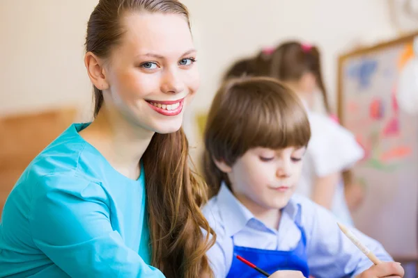 Children painting with teacher — Stock Photo, Image