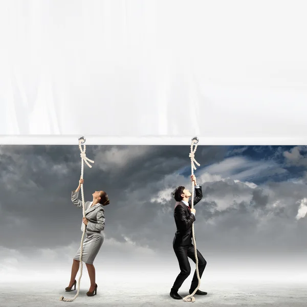 Businesspeople pulling banner — Stock Photo, Image