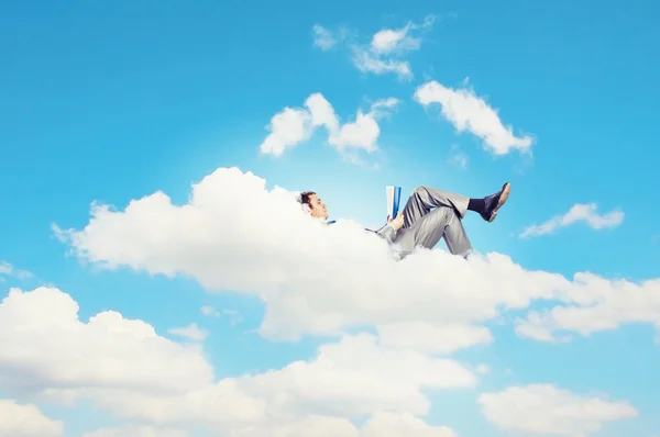 Geschäftsmann liegt auf Wolken — Stockfoto