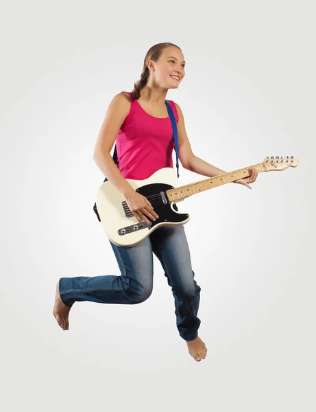 Giovane donna che suona la chitarra elettrica e salta — Foto Stock