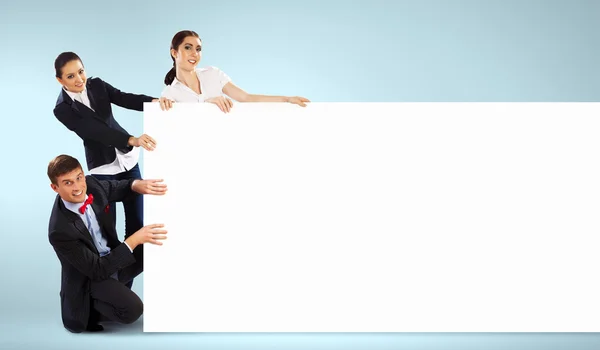 Three young people holding banner — Stock Photo, Image