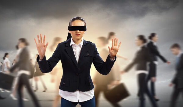 Businesswoman in blindfold among group of people