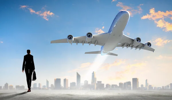 Mujer de negocios mirando el avión en el cielo — Foto de Stock