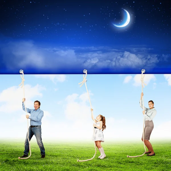 Family pulling banner — Stock Photo, Image