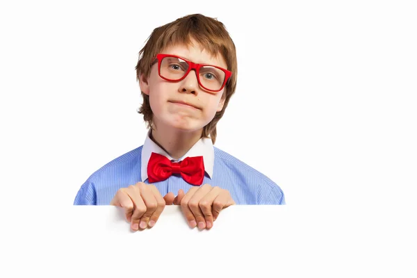 Αγόρι σχολείο σε κόκκινα γυαλιά κρατώντας λευκό τετράγωνο — Φωτογραφία Αρχείου
