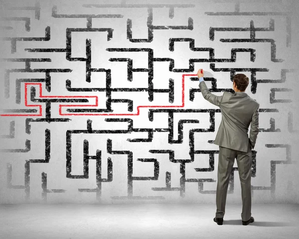 Businessman solving labyrinth problem — Stock Photo, Image