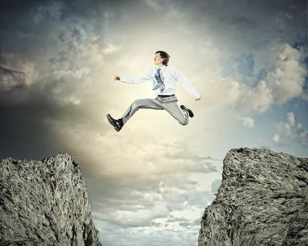 Businessman jumping over gap — Stock Photo, Image