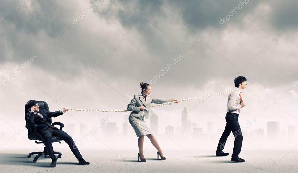 Three business people pulling rope