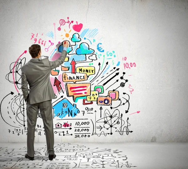 Businessman drawing sketches on wall — Stock Photo, Image