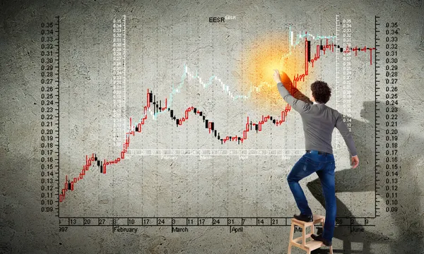 Молодой человек рисует график на стене — стоковое фото