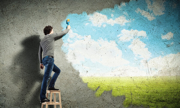 Young man drawing a cloudy blue sky Stock Photo