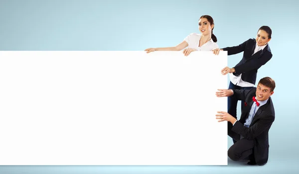 Three young people holding banner — Stock Photo, Image