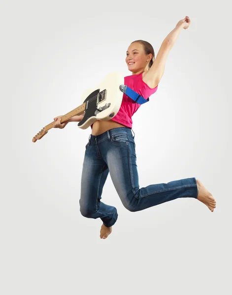 Młoda kobieta, grając na gitarze electro i skoki — Zdjęcie stockowe