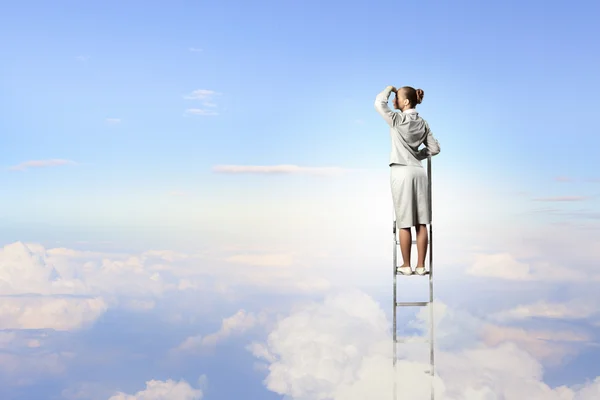 Businesswoman standing on ladder — Stock Photo, Image