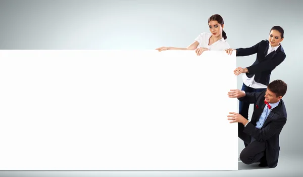 Three young people holding banner — Stock Photo, Image