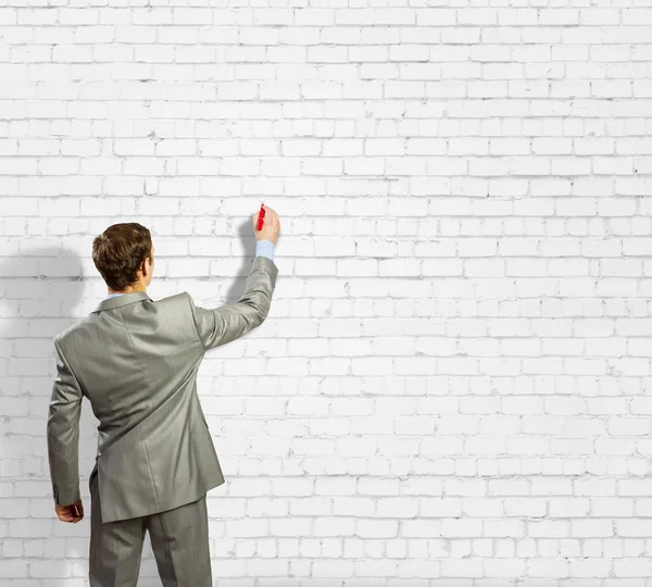 Businessman drawing sketches on wall — Stock Photo, Image