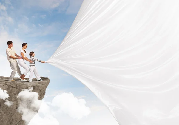 Young family pulling banner — Stock Photo, Image