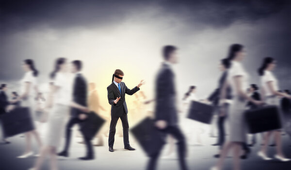 Businessman in blindfold among group of people