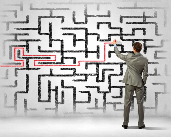 Businessman solving labyrinth problem — Stock Photo, Image