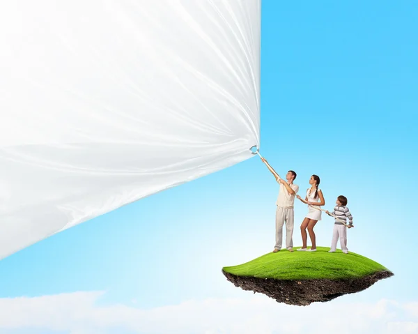 Young family pulling banner — Stock Photo, Image