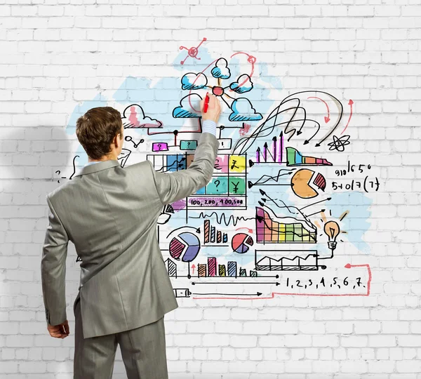 Businessman drawing sketches on wall — Stock Photo, Image