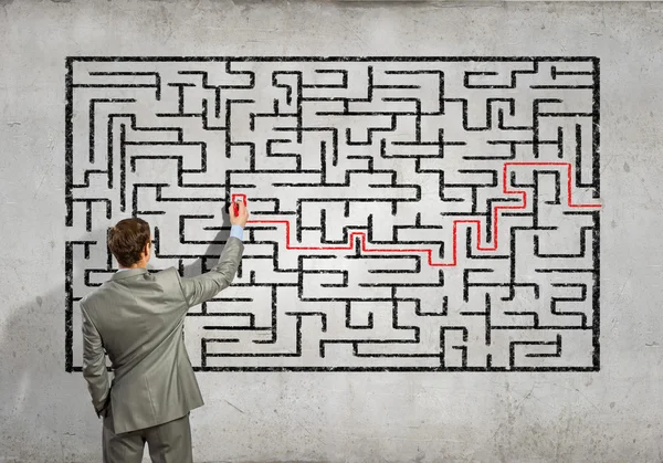 Businessman solving labyrinth problem — Stock Photo, Image
