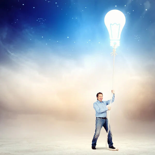 Adult man pulling rope with a bulb — Stock Photo, Image