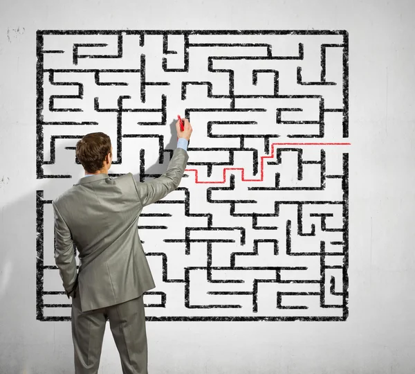 Businessman solving labyrinth problem — Stock Photo, Image