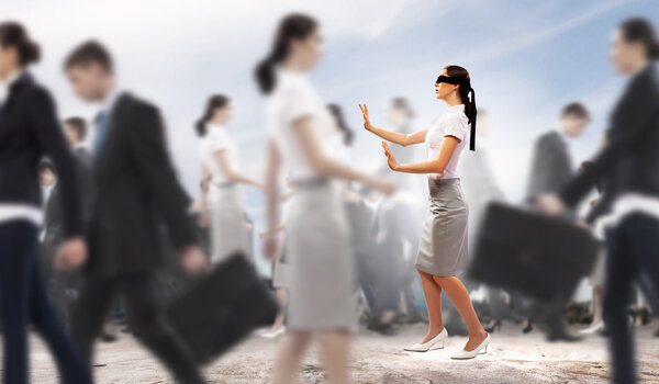 Businesswoman in blindfold among group of people