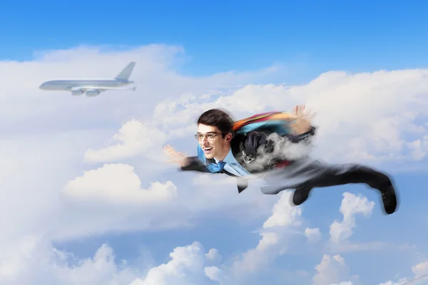 Joven hombre de negocios volando con paracaídas en la espalda —  Fotos de Stock
