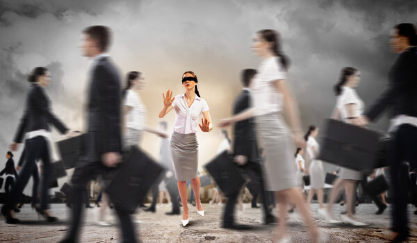 Businesswoman in blindfold among group of people