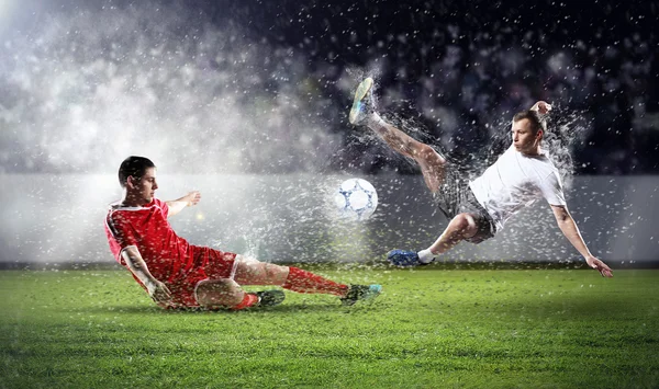 Two football players striking the ball — Stock Photo, Image