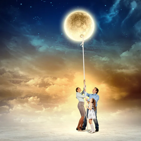 Family pulling moon — Stock Photo, Image